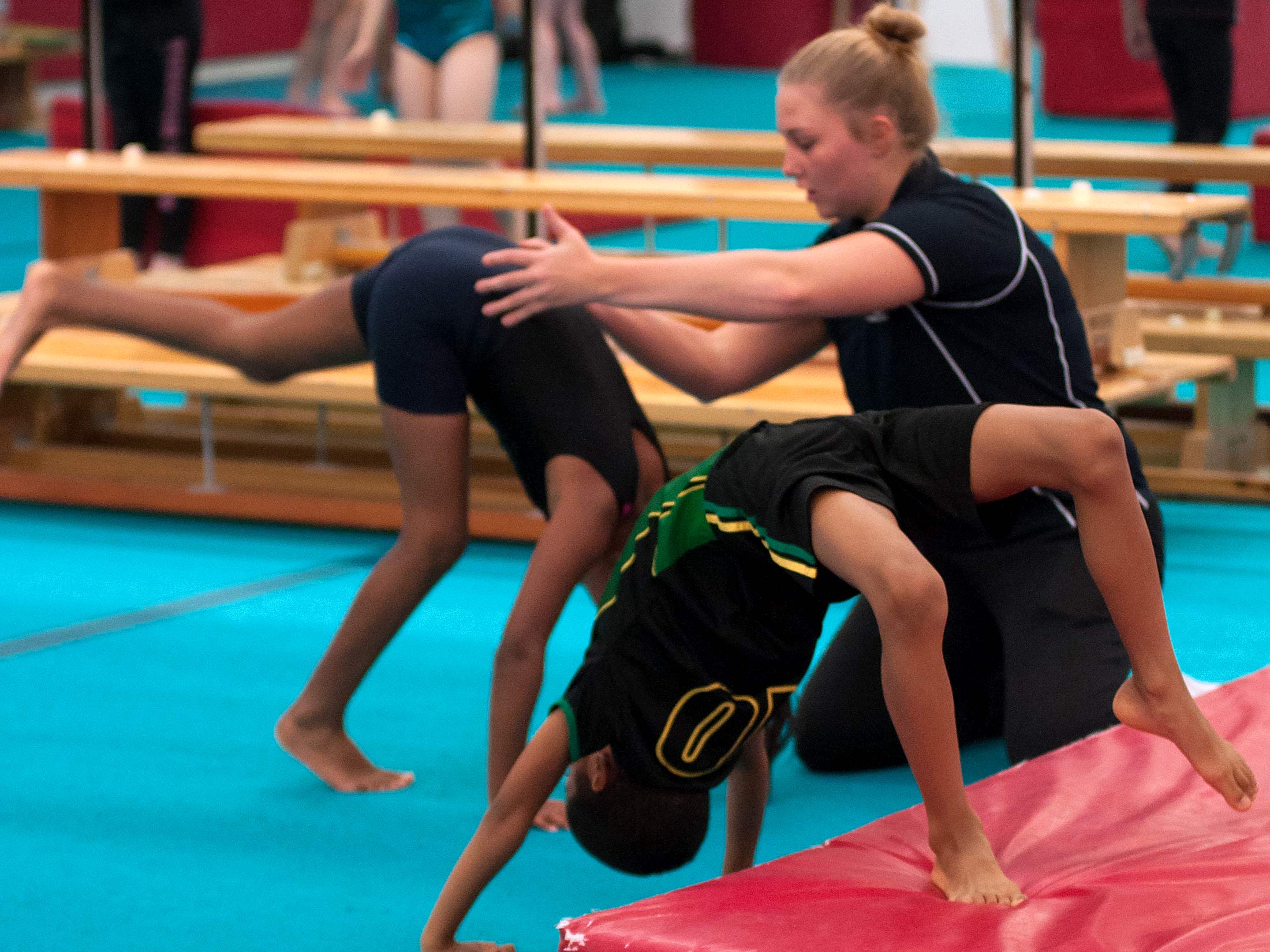 gymnasts being coached to handstand
